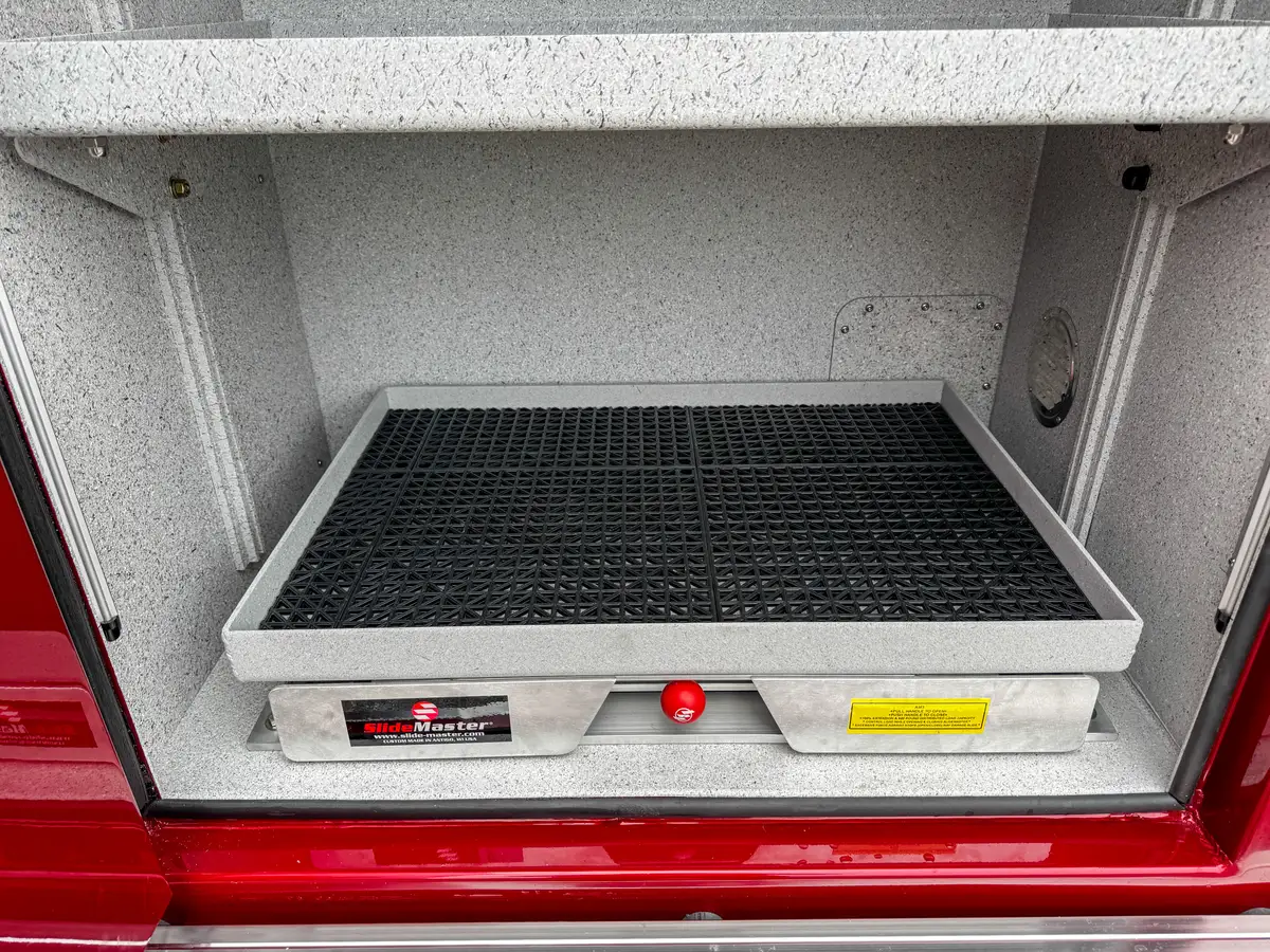 Deep compartment interior close-up with wiring and textured floor liner.